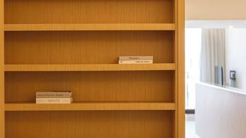 A wooden bookshelf with two books on the top shelf.