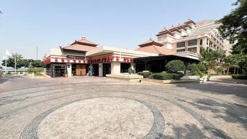 A hotel with a traditional architectural style, featuring a central courtyard with a patterned floor.