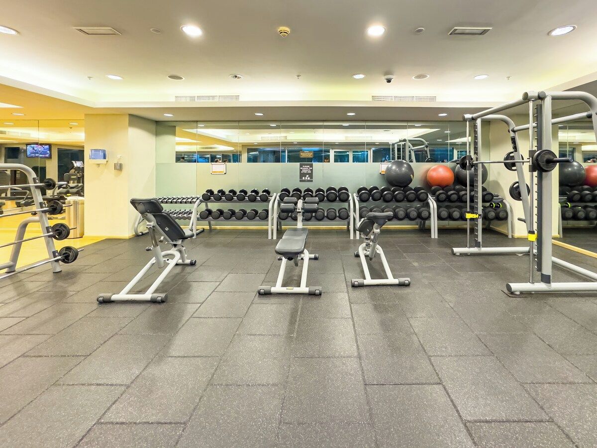 Une salle de sport équipée de tapis de course, d’haltères et d’appareils d’exercice.