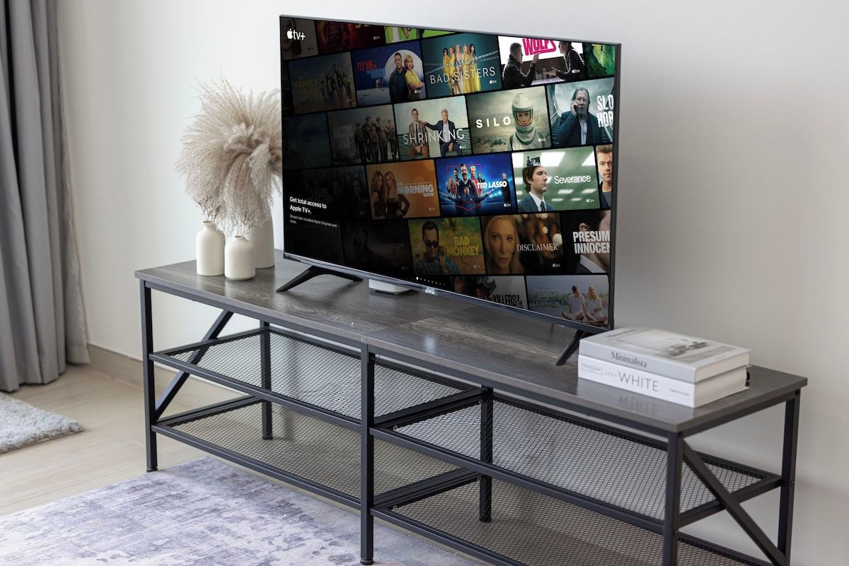Un televisor de pantalla plana sobre un soporte metálico, con un libro titulado 'Minimalista' encima.