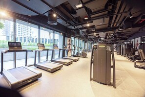 Ein Fitnessstudio mit Laufbändern, Kraftgeräten und Trainingsausrüstung.