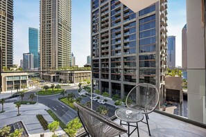 Um edifício alto com vários andares, um jardim no terraço e vista para a paisagem urbana.