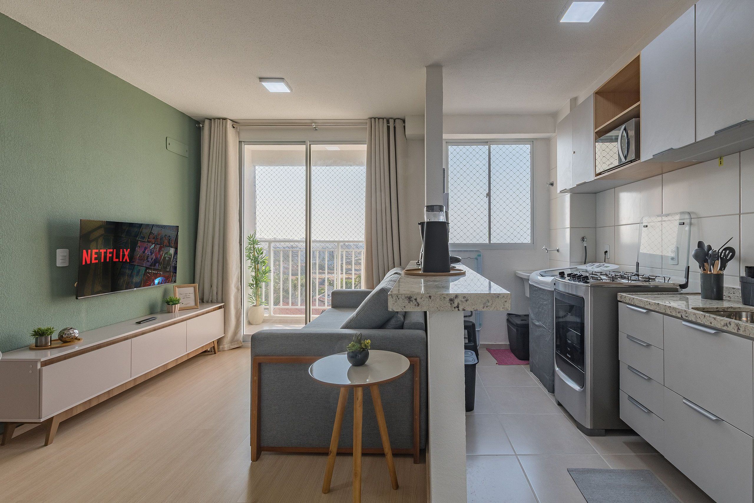 A modern apartment with a living room, kitchen, and balcony.