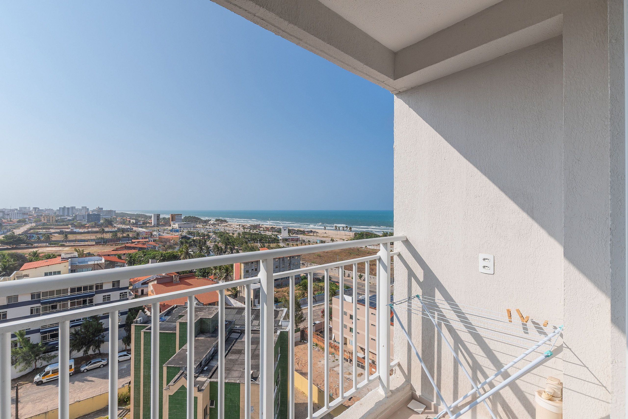 Ein Balkon mit Blick auf eine Küstenstadt, einschließlich Gebäude und dem Meer.