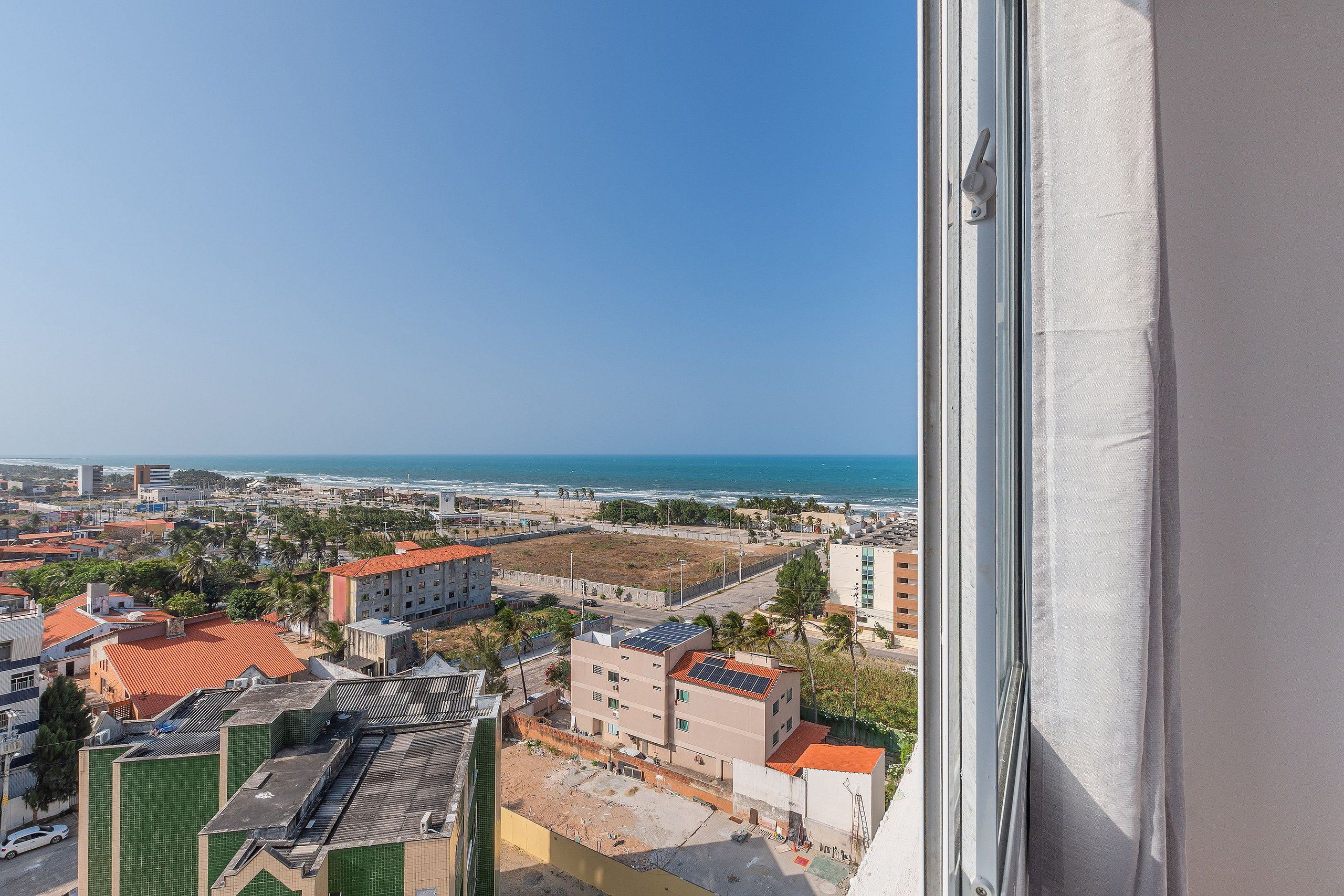 Un paisaje urbano costero con edificios, una playa y el océano.