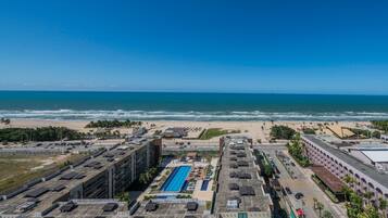 Een kusthotel met een zwembad op het dak, toegang tot het strand en uitzicht op de oceaan.