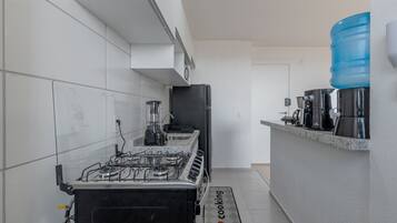 A modern kitchen with a gas stove, a coffee machine, and a water dispenser.