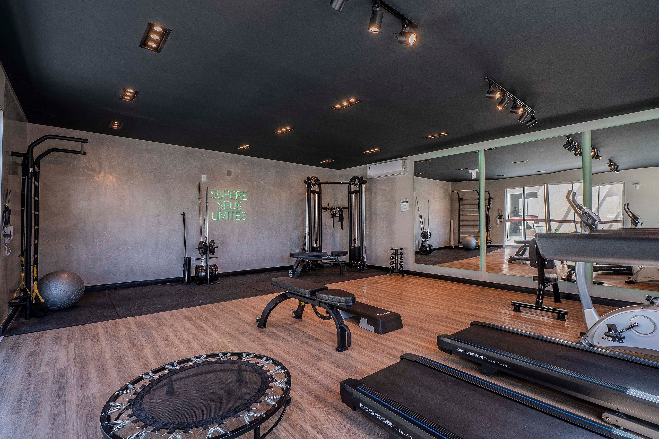 Una palestra con attrezzi da ginnastica, uno specchio e un tapis roulant.