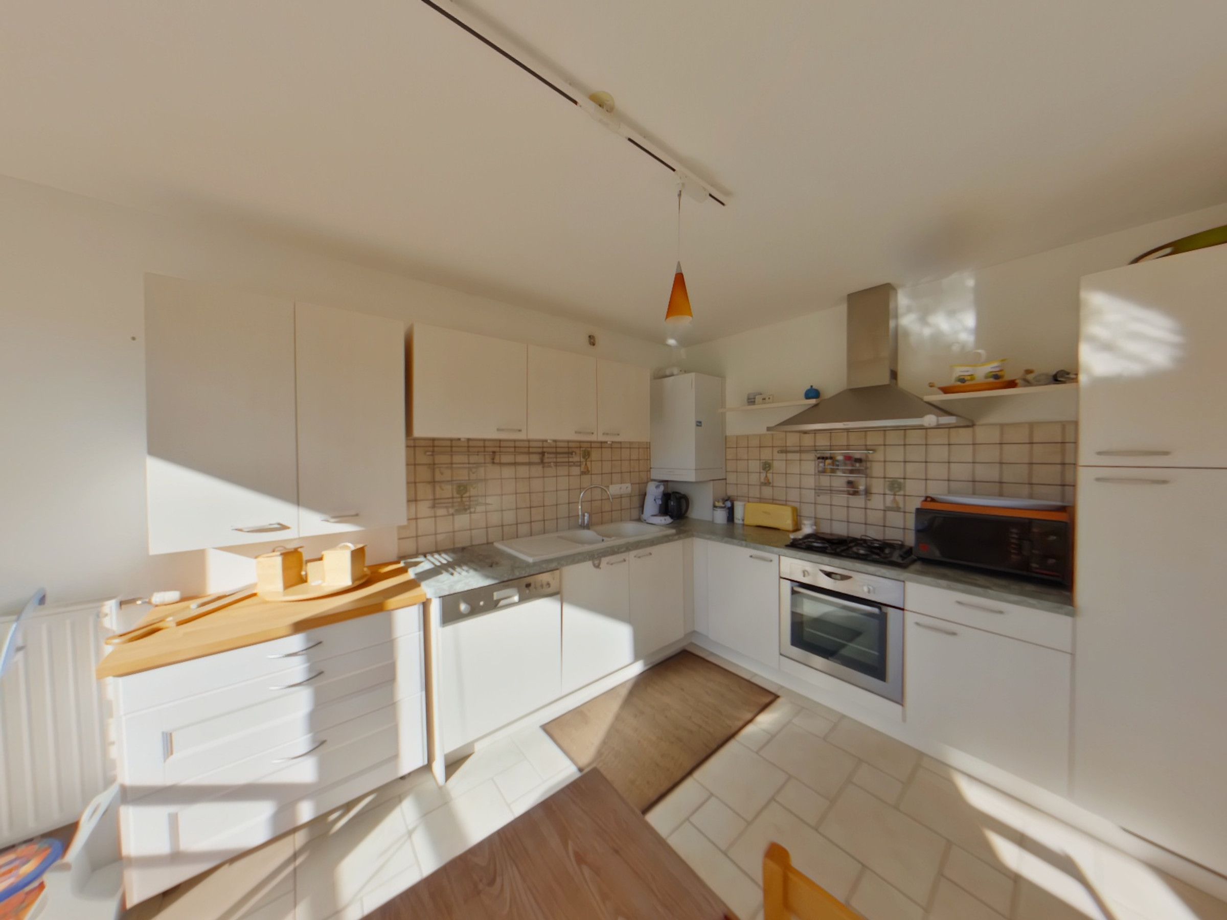 A modern kitchen with white cabinetry, a wooden countertop, a stove, and a microwave.