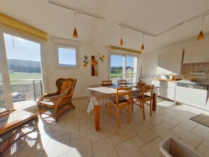 A spacious kitchen with a dining area, large windows, and a view of the outdoors. - Peaceful apartment in nature - 4 guests (Morbier)