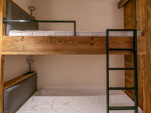 A bunk bed with a ladder, a shelf with a small item, and a plain wall. - Elegant apartment, pets welcome - 4 guests (Val-d'Isère)