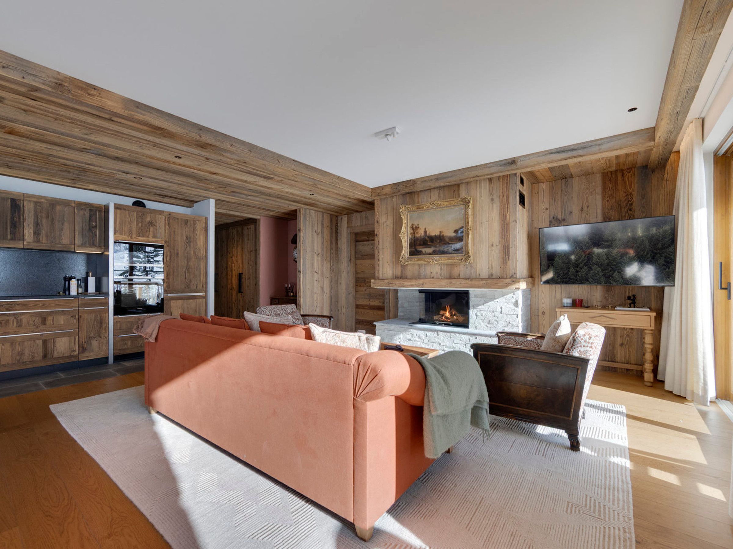 A modern living room with a fireplace, sofa, and television.