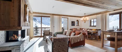 A spacious living area with a fireplace, a dining area, and a view of mountains.