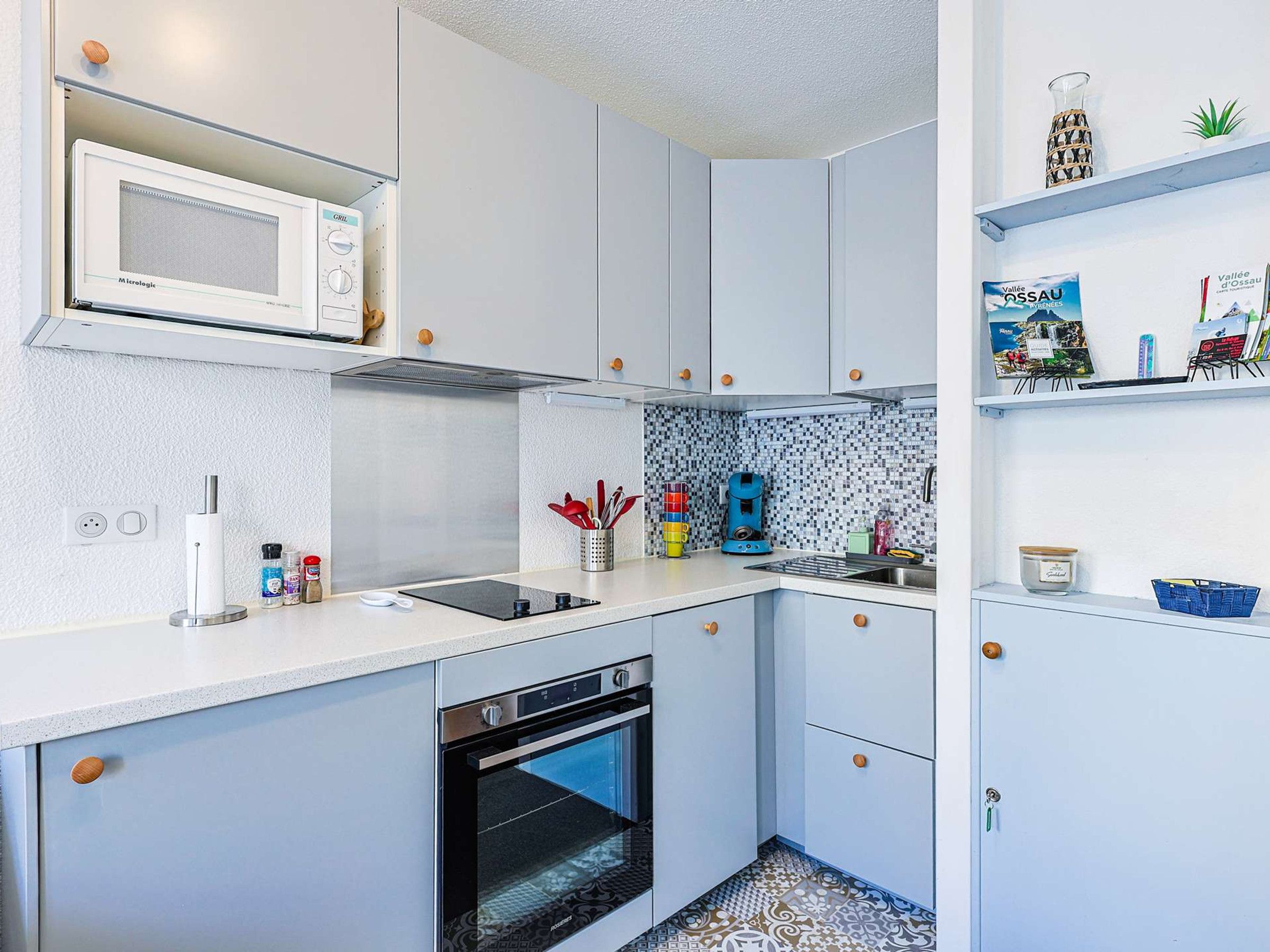 A modern kitchen with a microwave, oven, and coffee maker.