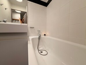 A bathroom with a bathtub, a mirror, and a sink. - Mountain studio tranquility, 5 guests (Vars)