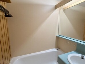 A bathroom with a bathtub, a sink, and a mirror. - Apartment with balcony - 4 guests, south view (Val Thorens)