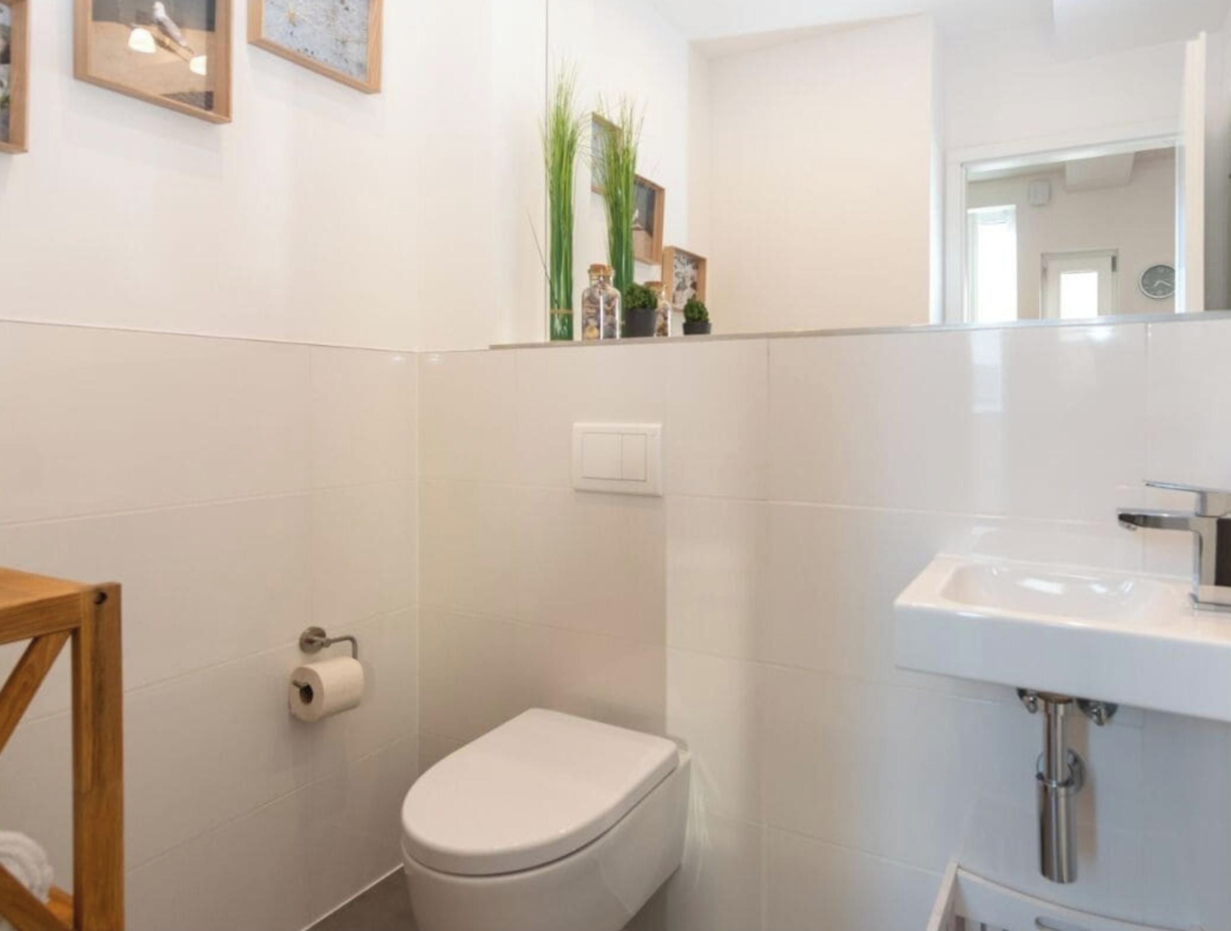 Une salle de bain avec des toilettes, un lavabo et un miroir.