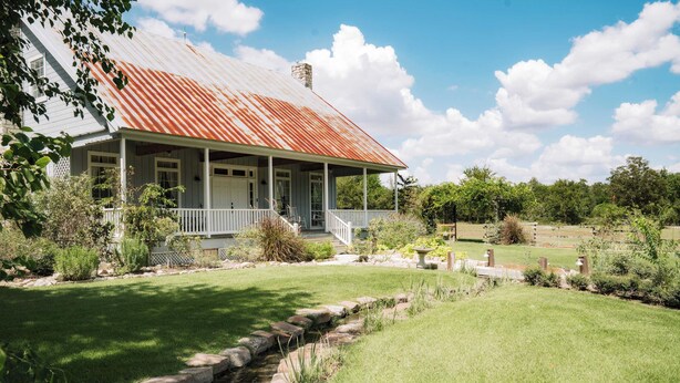 A house with a porch, a stone pathway, and a small stream. - NEW | Wisteria Ranch | Perfect Round Top Escape (Round Top)