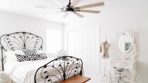 A bedroom with a bed, a bench, a dresser, a mirror, and a ceiling fan. - NEW | Wisteria Ranch | Perfect Round Top Escape (Round Top)