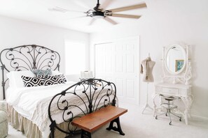 A bedroom with a bed, a bench, a dresser, a mirror, and a ceiling fan. - NEW | Wisteria Ranch | Perfect Round Top Escape (Round Top)