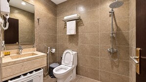 Ein Badezimmer mit Toilette, Waschbecken, Spiegel und Dusche.
