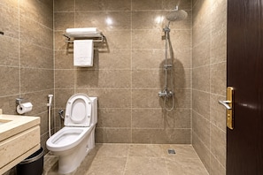 Un baño con inodoro, lavabo y ducha.