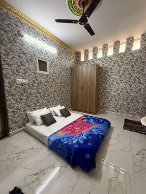 A bedroom with a bed, a wardrobe, a ceiling fan, and a small window. - Coconut Sooru Homestay Channapatna (Kurnagere)