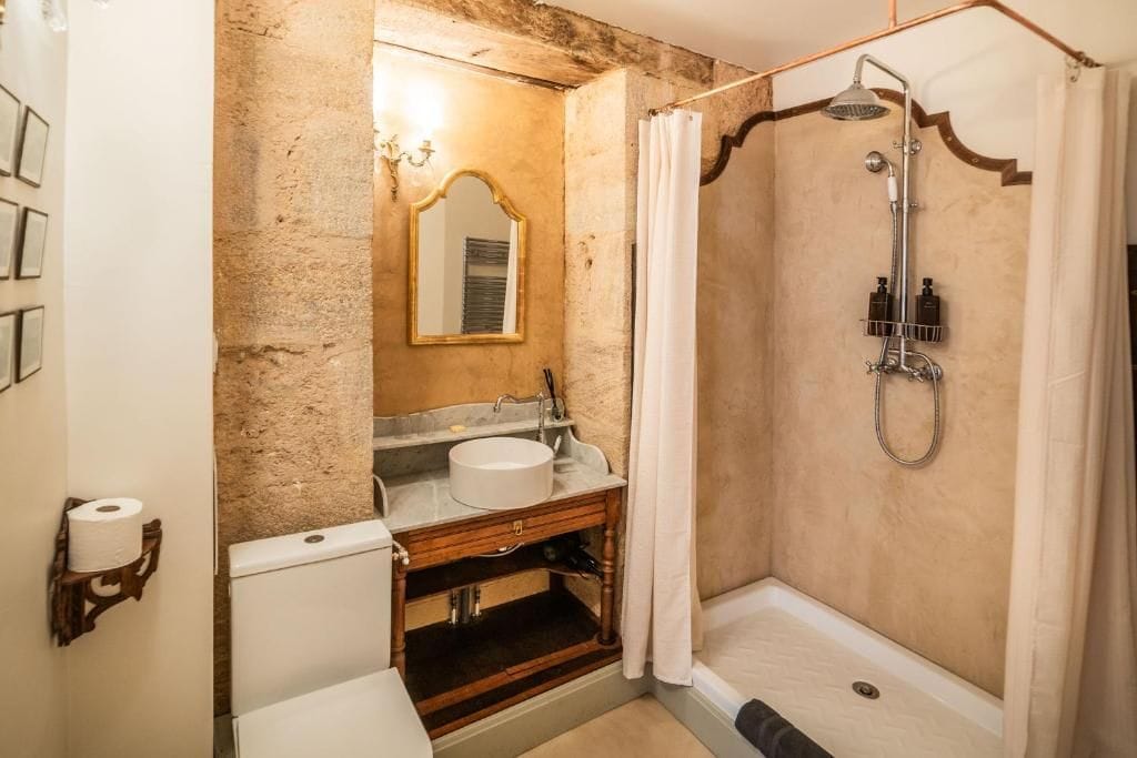 A bathroom with a shower, sink, and toilet.