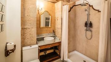 A bathroom with a shower, sink, and toilet.