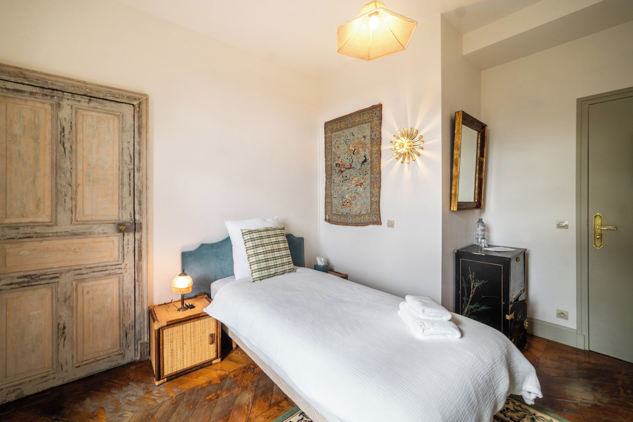 Una camera da letto con un letto, una lampada da comodino, decorazioni a parete e un armadio.