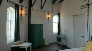 Una habitación con cama, escritorio, armario y ventana.