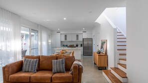 Ein modernes Interieur mit Wohnbereich, Küche und Treppe.