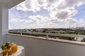 A balcony with a view of a cityscape, including buildings and a stadium. - #425 Cozy Getaway in Albufeira | Shared Pools (Albufeira)