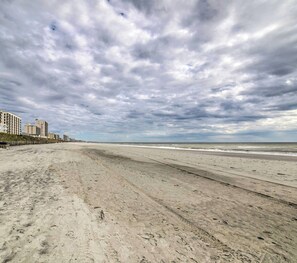 Une plage bordée d’une rangée de bâtiments.