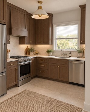 A kitchen with wooden cabinets, stainless steel appliances, a window with blinds, and a textured rug. - "Hey Jude"~Longboat Key ~Waterfront Bayside Escape (Longboat Key)