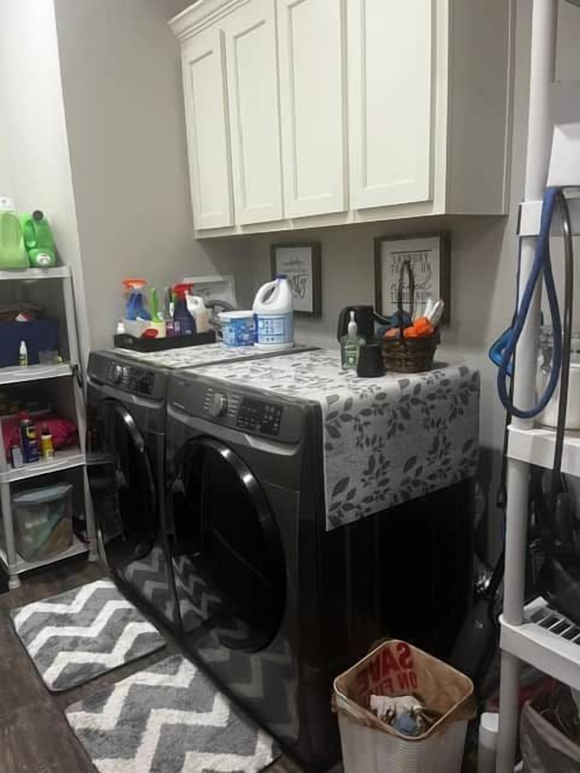 A laundry area with a washing machine, dryer, and a basket.