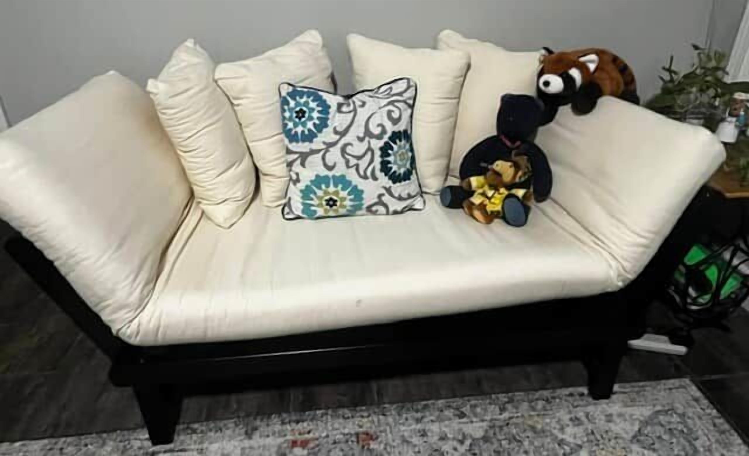 A beige sofa with decorative pillows and a stuffed toy.
