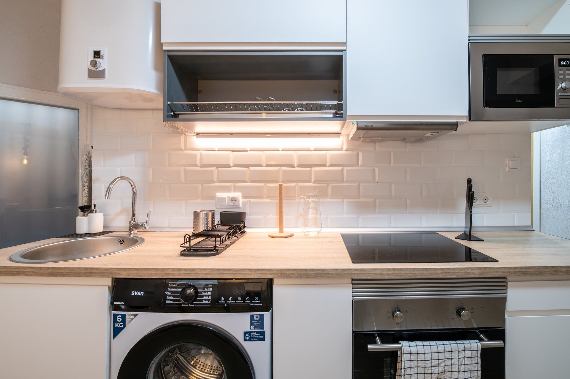 A modern kitchen with a built-in dishwasher, a microwave, and a stainless steel oven.