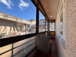 A balcony with a view of neighboring buildings, a chair, and a table. - Elegant 3BR Stay | Heart of Şişli (Istanbul)