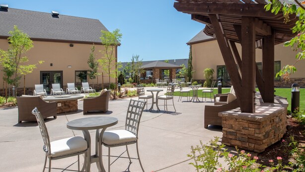 An outdoor patio area with seating arrangements, a pergola, and a stone planter. - 1 Bedroom King Suite w/ Full Kitchen + Breakfast (Hillsboro)