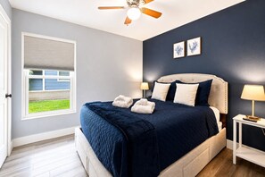 A bedroom with a bed, a ceiling fan, a window, and two wall-mounted picture frames. - Heated Pool~Windsor Resort~Near Disney~Game Room (Kissimmee)