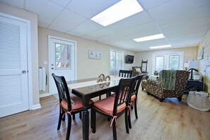 A dining area with a table and chairs, a sofa, and a television. - Songbird Bluff- hottub-wifi-pets ok- view (Mineral Bluff)