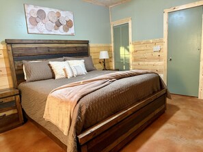 A wooden bed with a headboard, a bedside table, and a wall-mounted lamp. - Songbird Bluff- hottub-wifi-pets ok- view (Mineral Bluff)