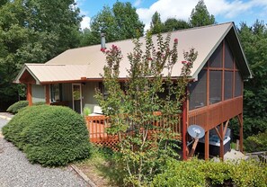 A two-story cabin with a sloped roof, a deck, and a hot tub. - Songbird Bluff- hottub-wifi-pets ok- view (Mineral Bluff)