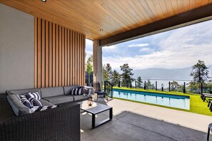 Un área de estar moderna al aire libre con piscina y vistas a las montañas.