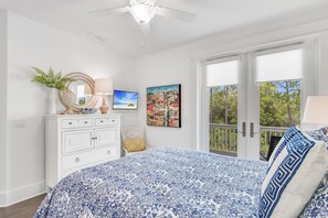 A bedroom with a bed, dresser, artwork, and a view through the door. - Beachy Keen 30A (Santa Rosa Beach)