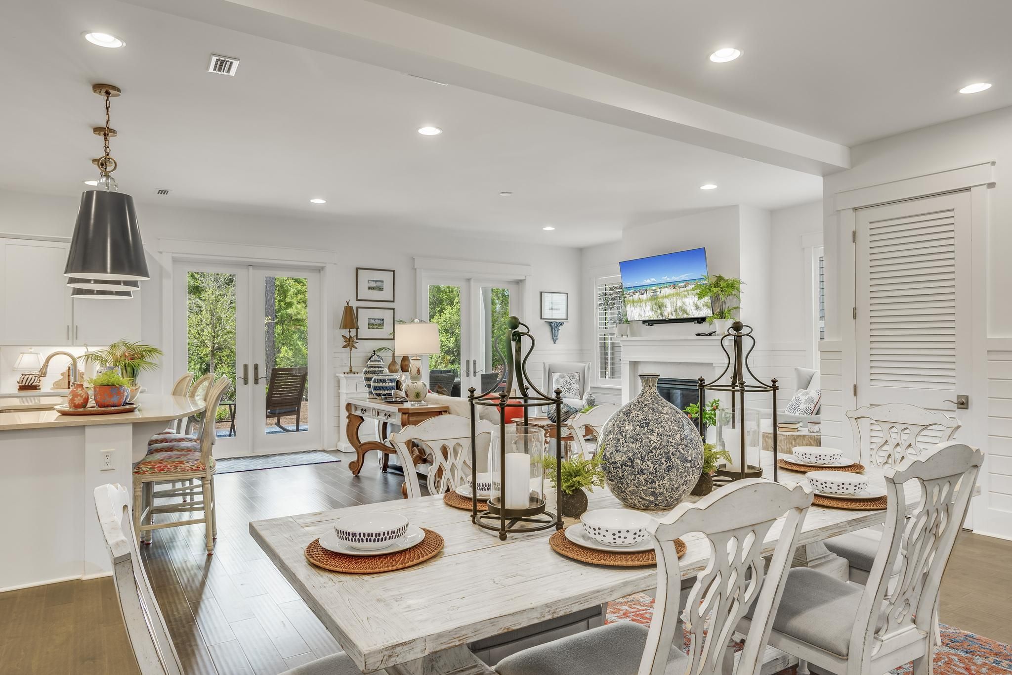 A spacious dining area with a white table set for four, surrounded by white chairs.