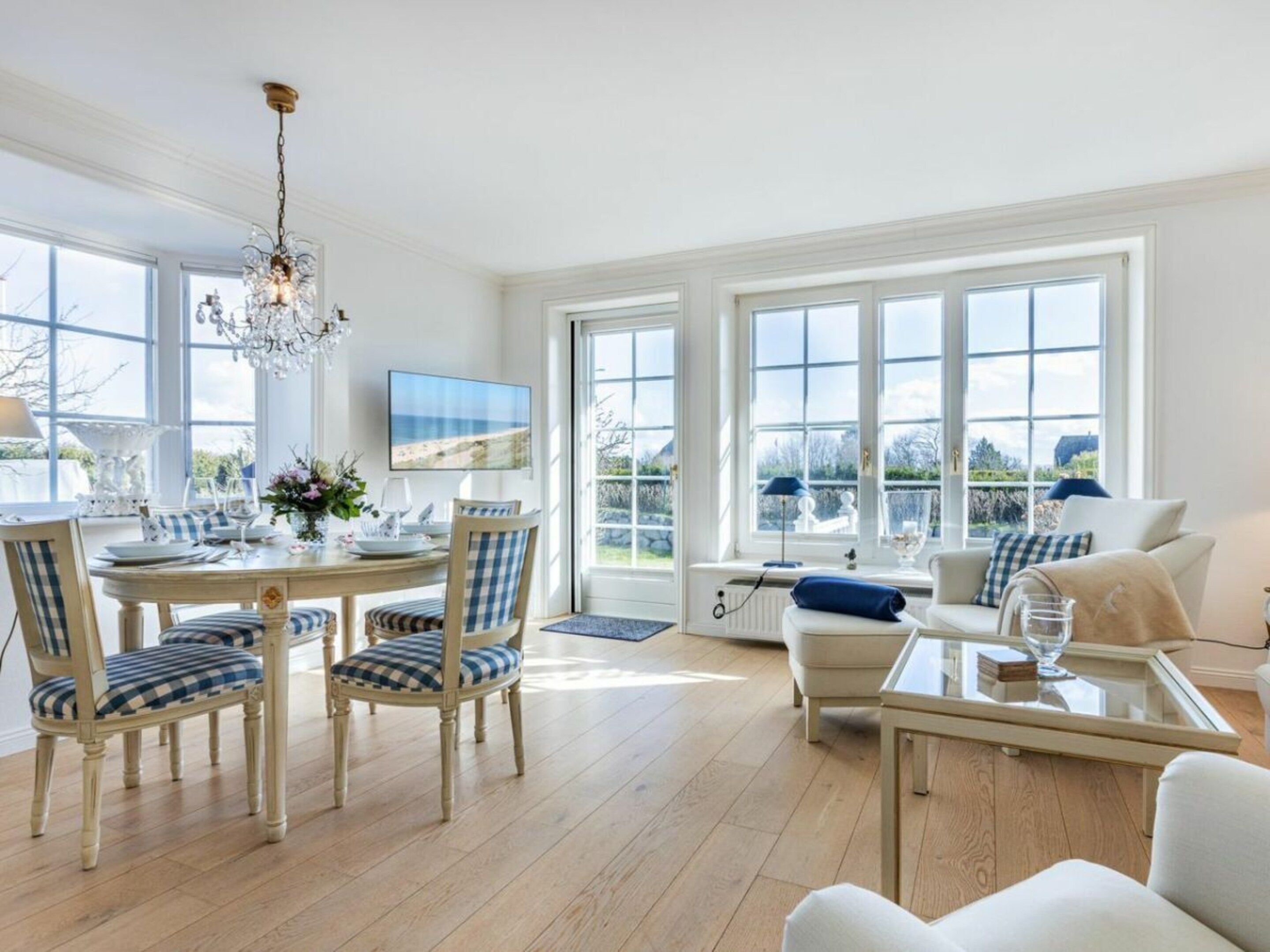 A spacious room with a dining area, a sofa, and a television.