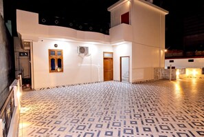 A building with a patterned floor, a door, and an air conditioning unit.