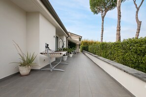 A clean, modern outdoor corridor with potted plants and a hammock. - Apartment 'Casa Mimosa' with Private Terrace, Private Garden and Wi-Fi (Camaiore)